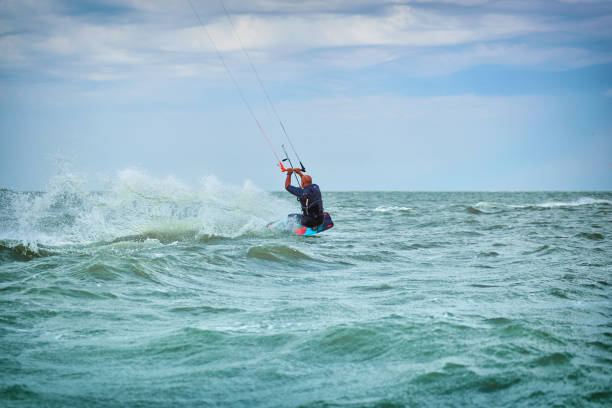 istock Man riding a kite surfing on the waves in the summer. 912129120