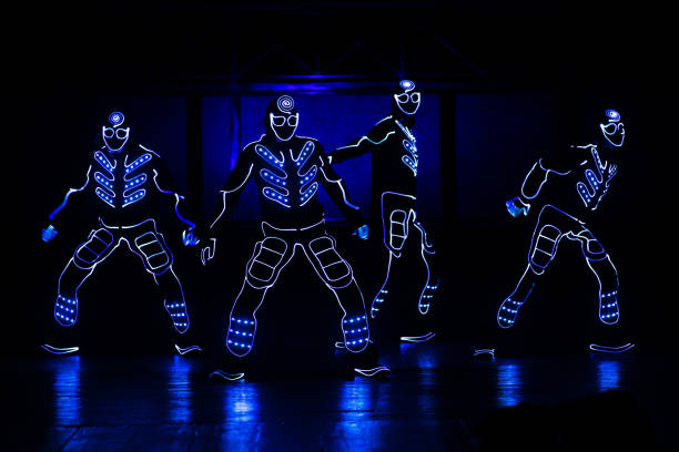 dancers in led suits on dark background, colored show