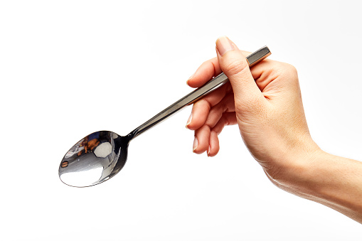 The woman's right hand holds a spoon on a white background.