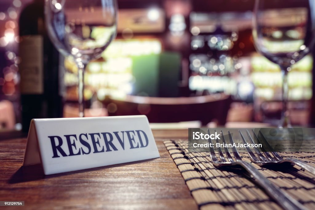 Muestra reservado en mesa de restaurante con bar fondo - Foto de stock de Restaurante libre de derechos