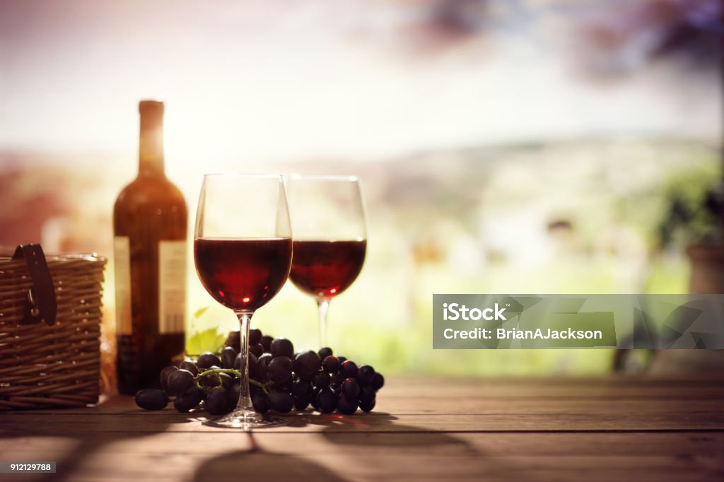 Red wine bottle and glass on table in vineyard Tuscany Italy Wine Stock Photo