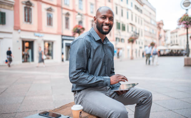 istock Businessman sitting on a bench and using digital tablet in the city 912130026