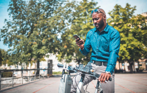 istock Businessman sitting on a bike and using phone 912130114