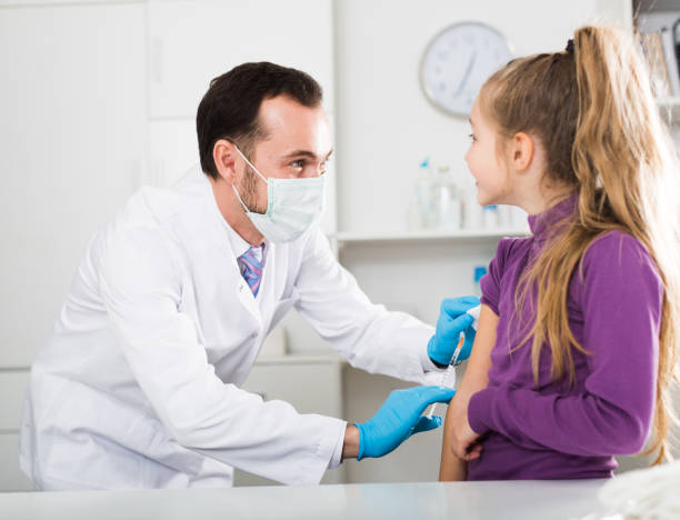 istock Male doctor injecting little patient 912130382