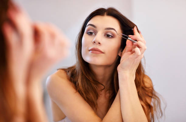 istock Attractive young woman doing make-up while looking at the mirror in bathroom 912130716