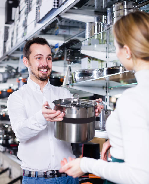 istock Salesman proposes to look at saucepan 912133666