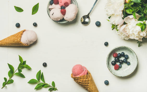 istock Ice cream scoops, peonies and berries over white background 912137744