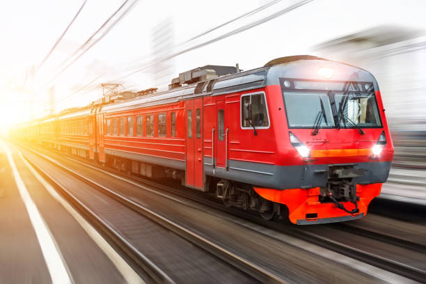 istock Red passenger train with headlights on rushing through the railway in the evening. 912138144