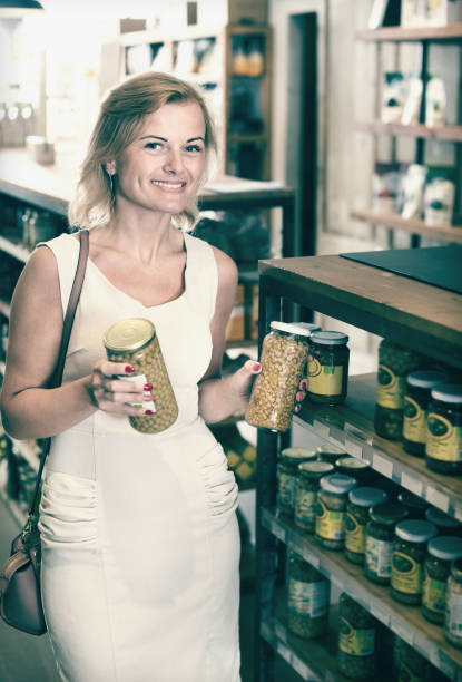istock Female choosing preserve peas in jar 912138638