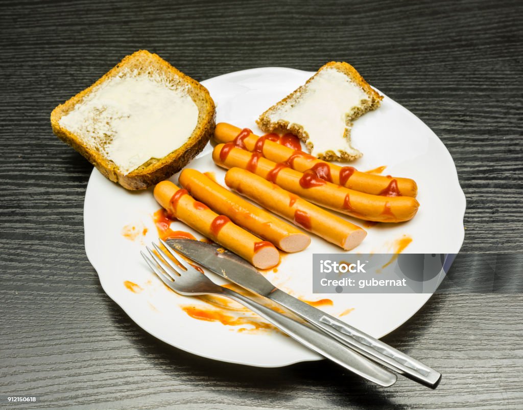 Plato con salchichas, salsa de tomate y las rodajas con mantequilla durante el desayuno. - Foto de stock de Alimento libre de derechos