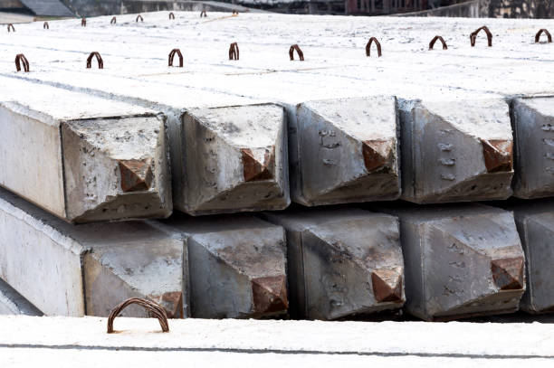 istock Stack of prestressed concrete piles on ground for foundation construction work. The process of construction of the embankment for protecting riverbank collapse by concrete foundation piles. 912150684