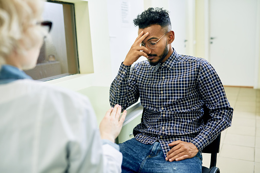 Sad young Arabian patient knowing medical test results while visiting doctor in hospital