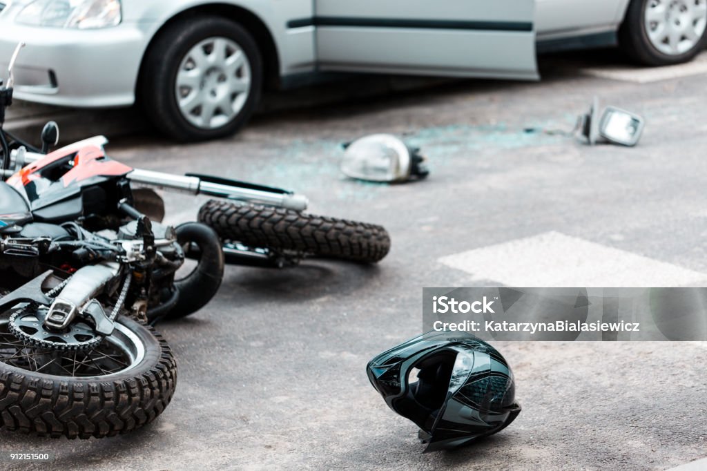 Overturned motorcycle after collision Overturned motorcycle and helmet on the street after collision with the car Crash Stock Photo