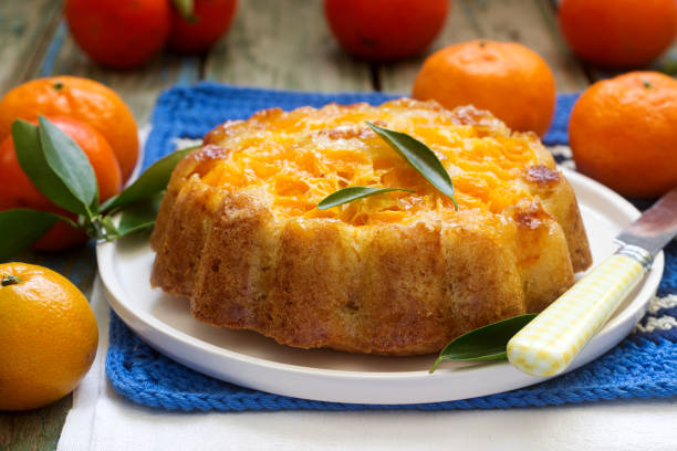 istock Mandarin cake and tangerines on rustic background. 912159420