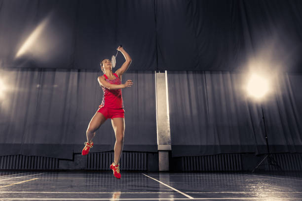 giovane donna che gioca a badminton in palestra - badminton school gymnasium shuttlecock sport foto e immagini stock