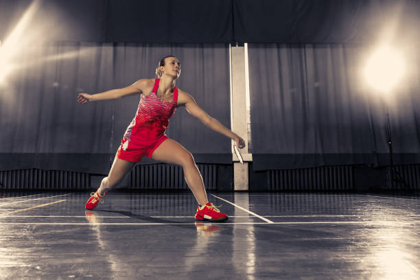 giovane donna che gioca a badminton in palestra - badminton school gymnasium shuttlecock sport foto e immagini stock