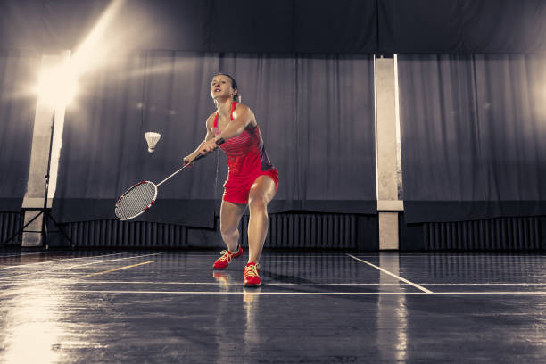 giovane donna che gioca a badminton in palestra - badminton school gymnasium shuttlecock sport foto e immagini stock