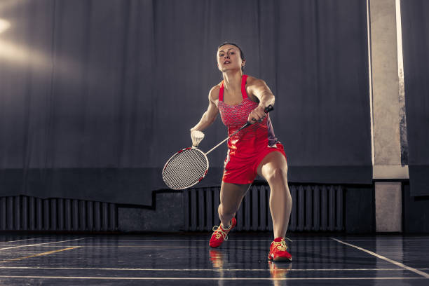 giovane donna che gioca a badminton in palestra - badminton school gymnasium shuttlecock sport foto e immagini stock