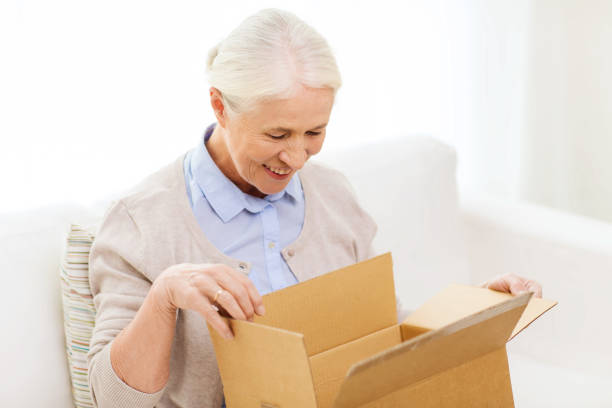 istock happy senior woman with parcel box at home 912166352