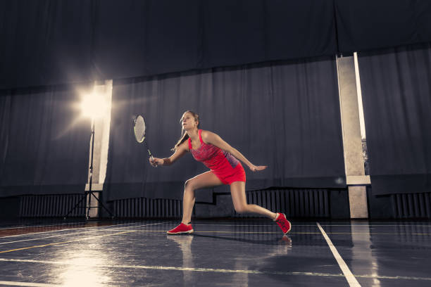 jovem mulher jogando badminton no ginásio - badminton school gymnasium shuttlecock sport - fotografias e filmes do acervo