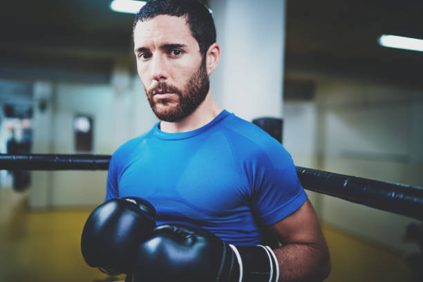 istock Young caucasian athlete in black gloves looking at the camera.Blurred background.Horizontal. 912167826