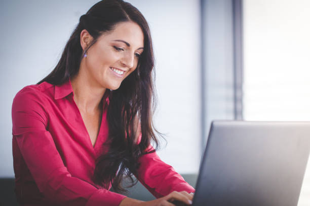 istock Beautiful brunette business woman standing in a boardroom working on a tablet computer 912168404