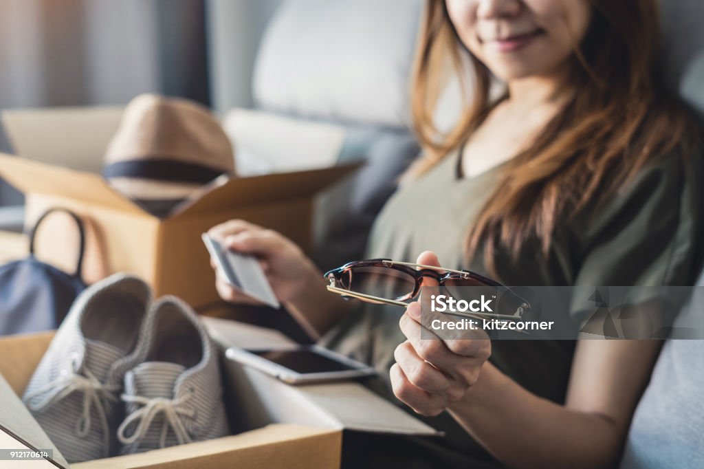 young woman received online shopping parcel opening boxes young woman received online shopping parcel opening boxes and buying fashion items by using credit card Package Stock Photo