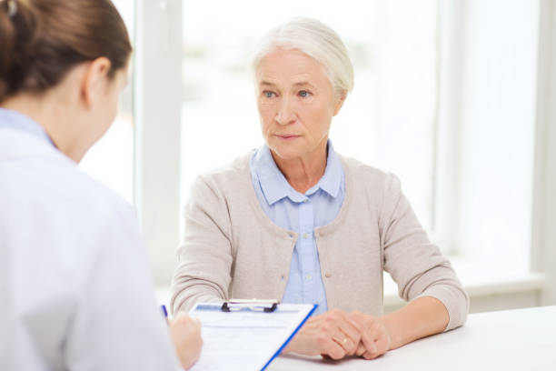 doctor with clipboard and senior woman at hospital - healthcare and medicine nurse doctor general practitioner imagens e fotografias de stock