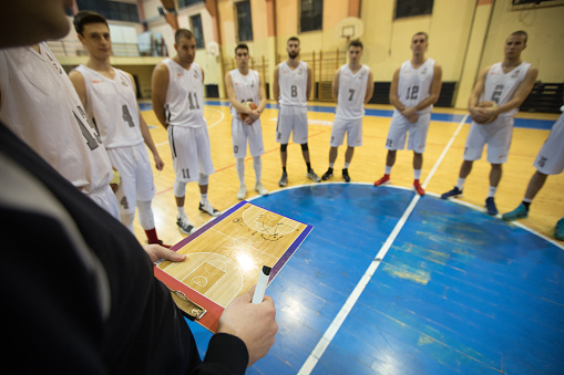 Basketball coach advising his players during practice