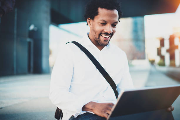 istock Happy African American man working with electronic touch pad pro with holding in hands.Concept of guy using Internet-enabled electronic device outside.Blurred background.Cropped. 912172820