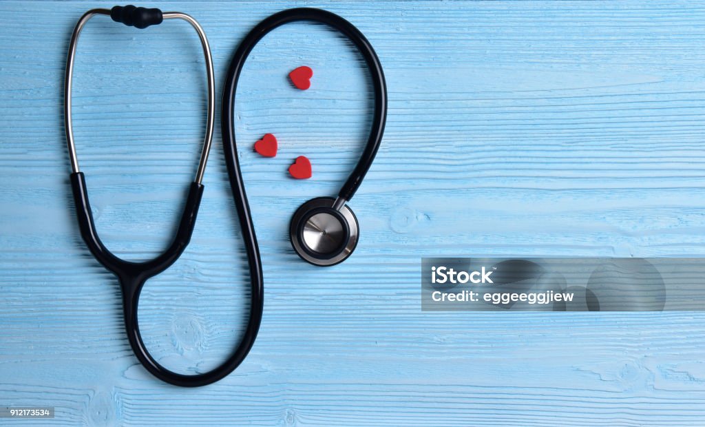 Three Red hearts with stethoscope. Three Red hearts with stethoscope on blue wooden background. Copy space. Valentines day. Doctor Stock Photo