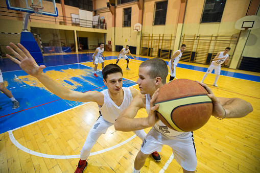 Young basketball players playing on basketball court,dribbling