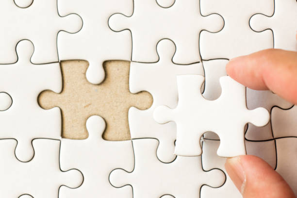 istock Closed up background of white plain jigsaw with hand that hold missing piece to match or fulfill 912200066