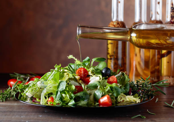 istock Green salad with olive oil pouring from a small bottle. 912201624