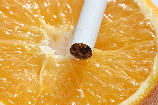 Orange or cigarette? stock photo