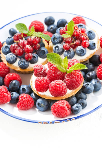 istock mini cakes with sweet cream and berries on plate, vertical 912209044