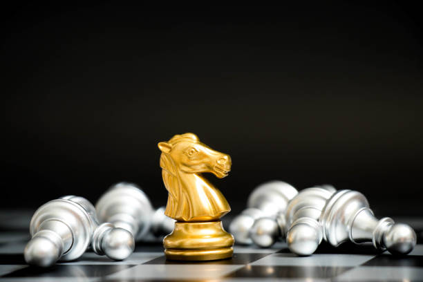 istock Gold horse in chess game face with the another silver team on black background (Concept for company strategy, business victory or decision) 912215578