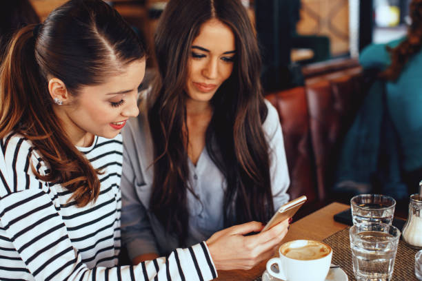 istock Two young women looking in smartphone screen in cafe 912220028