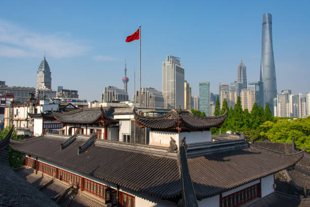 View of the Pudong; the financial district of Shanghai. Seen over the traditional Chinese rooftops of the old town center. At the Pudong the famous skyscrapers; Shanghai Tower, Oriental Pearl Tower, Jin Mao Tower and the Shanghai World Financial Center can be seen.