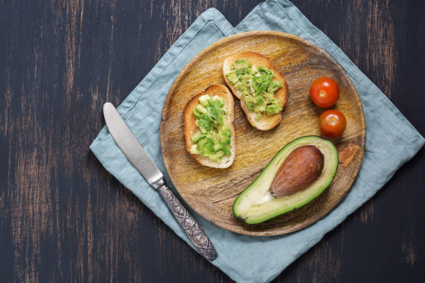 istock Toasts with avocados are served on a plate on a blue background. 912223678