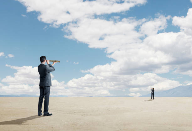 istock Two People Looking At Each Other Through Spyglasses 912223926