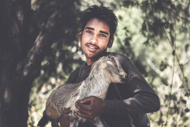 istock Indian boy holding a young kid goat 912226350