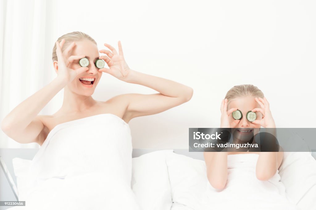 Mutter und Tochter hatten einen Tag Spa. Sie sind in weißen Badetücher mit Gurkenscheiben auf die Augen - Lizenzfrei Mutter Stock-Foto