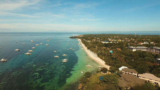 Aerial view of tropica Alona beach on the island Bohol, resort, hotels, Philippines. Beautiful tropical island with sand beach, palm trees. Tropical landscape. Seascape: Ocean, sky, sea. Travel concept.
