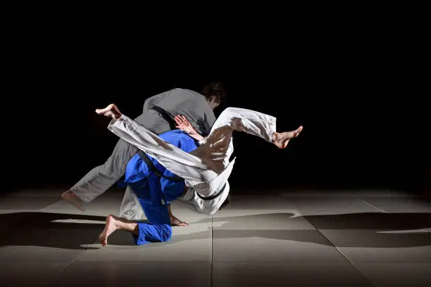 Two black belt judo fighters throwing SEOI OTOSHI. Image created as multiple exposure to show the motion sequence.