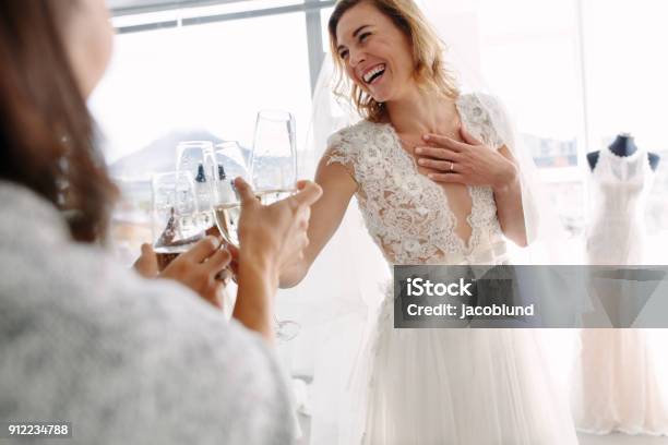 Bride Toasting Champagne With Friends In Bridal Boutique Stock Photo - Download Image Now