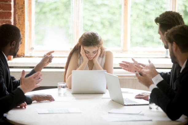 male colleagues pointing fingers at upset female boss on meeting - bigotry imagens e fotografias de stock