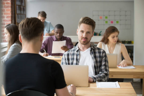 istock Businessman looking at camera working in co-working with diverse people 912235048