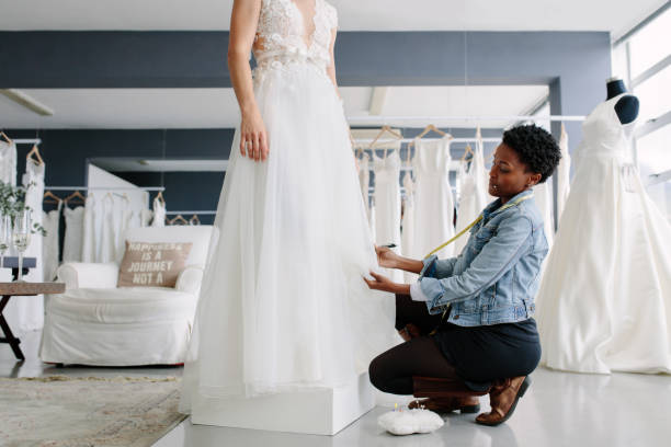 istock Woman making adjustment to wedding gown in designer studio 912235456