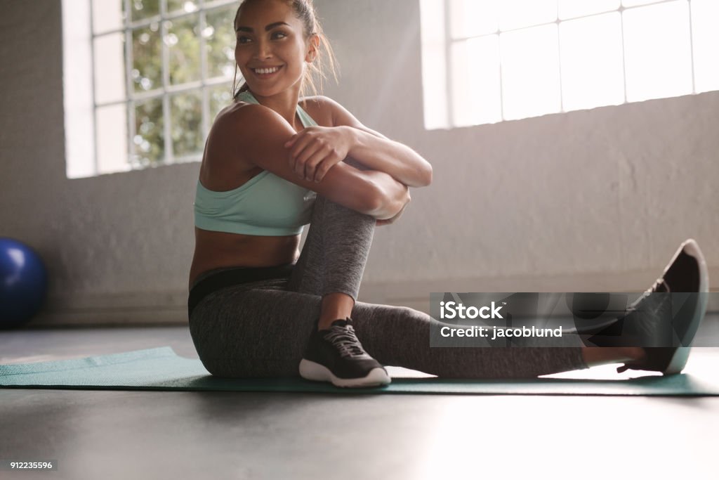 Sourire de femelle au gymnase prenant une pause de la séance d’entraînement - Photo de Femmes libre de droits